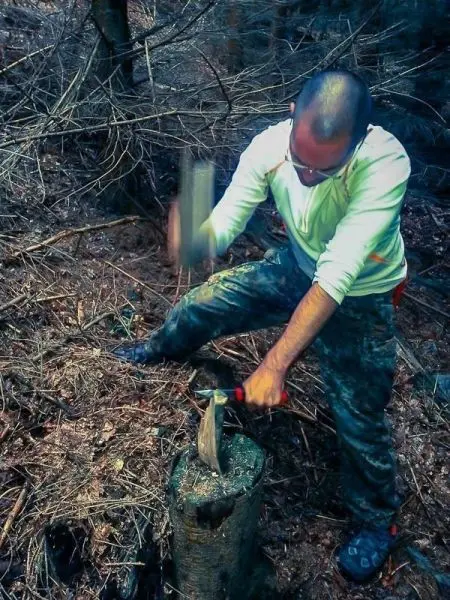 Messer schlägt auf Holzstück, um es zu bearbeiten