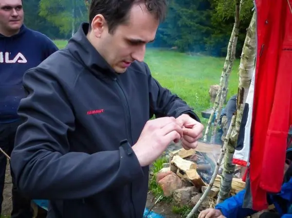 Mann bereitet Zunder für ein kleines Bodenfeuer vor