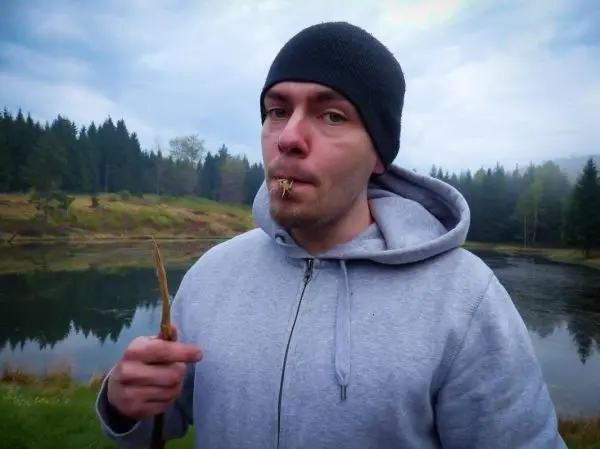 Person hält einen Stock und hat etwas im Mund