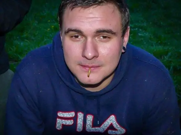 Person mit einem Stift im Mund sitzt im Freien