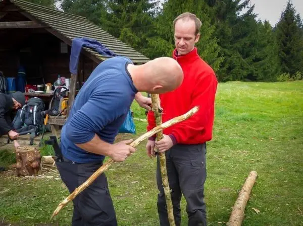 Zwei Personen bearbeiten Holzstöcke zur Herstellung eines Werkzeugs