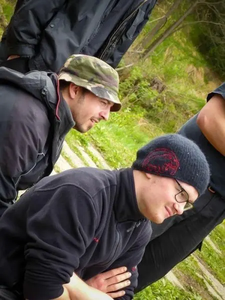 Zwei Personen sitzen auf dem Boden und beobachten eine Aktivität