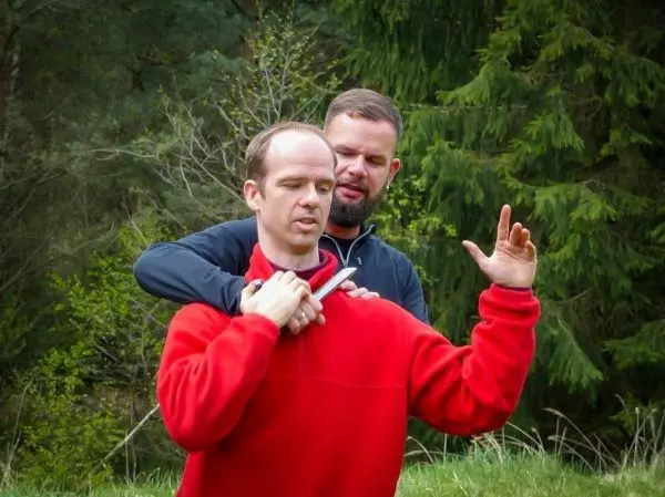 Zwei Personen üben eine Selbstverteidigungstechnik im Freien