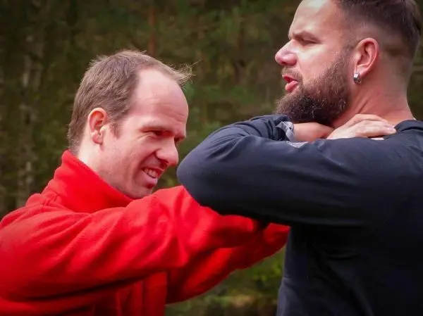 Zwei Personen üben eine Selbstverteidigungstechnik im Freien