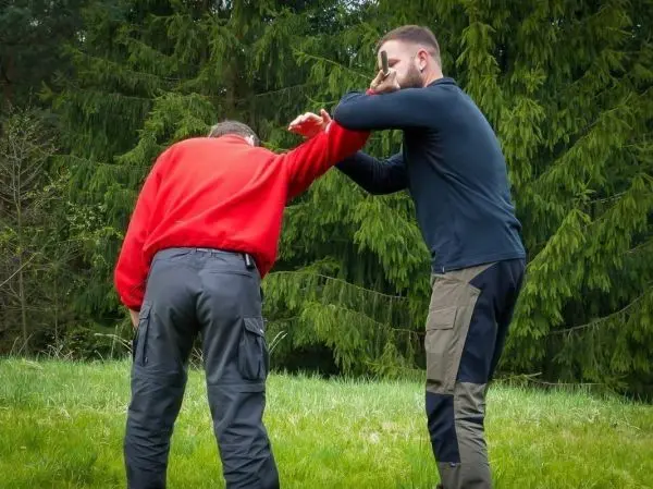 Zwei Personen üben eine Selbstverteidigungstechnik im Freien