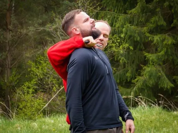 Zwei Personen üben eine Selbstverteidigungstechnik im Freien aus