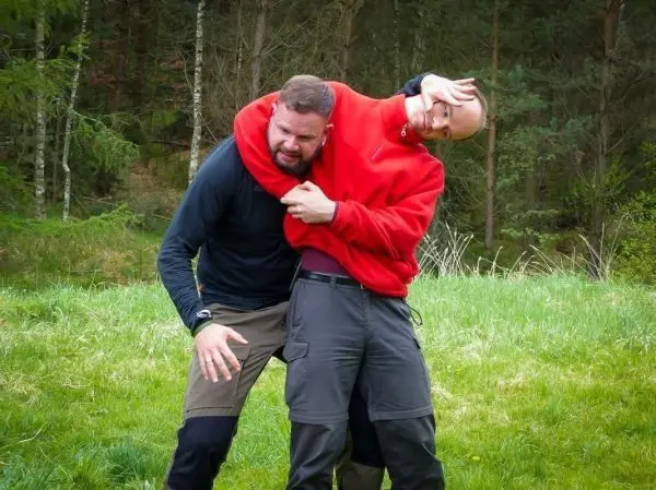 Zwei Personen üben eine Selbstverteidigungstechnik im Freien aus