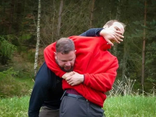 Zwei Personen üben eine Selbstverteidigungstechnik im Freien aus