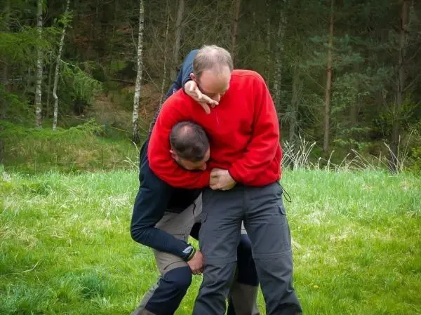 Zwei Personen üben eine Technik zur Kontrolle des Gegners im Freien