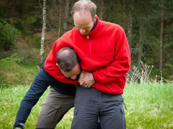 Zwei Personen üben eine Technik zur Kontrolle in einer natürlichen Umgebung