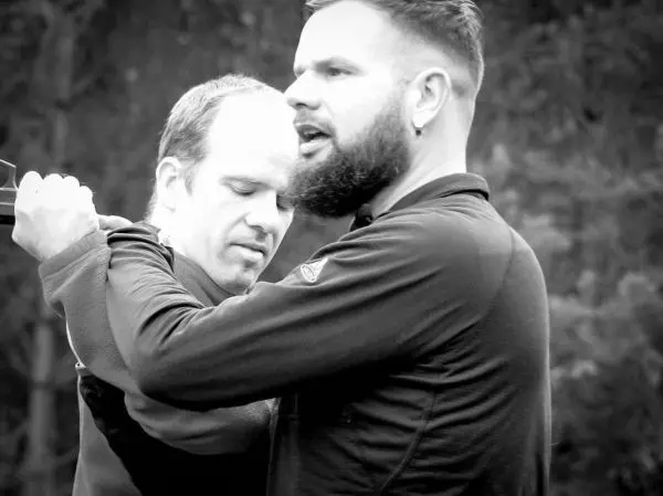 Zwei Personen üben eine Technik zur Selbstverteidigung oder Kontrolle aus