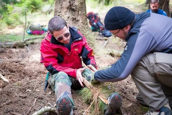 Ein Teilnehmer verbindet eine Verletzung am Bein mit improvisiertem Verband