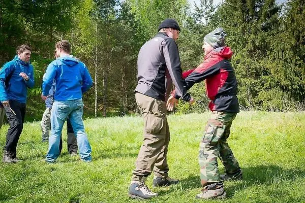 Gruppendynamik im Freien, Teilnehmer üben körperliche Interaktion auf einer Wiese