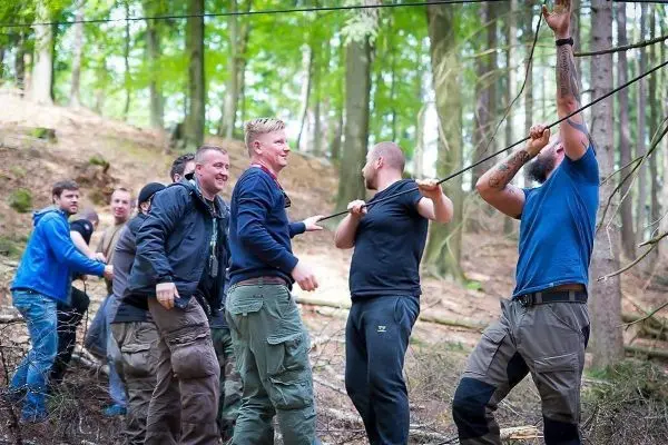 Gruppierung zieht an einem Seil in einem Waldgebiet