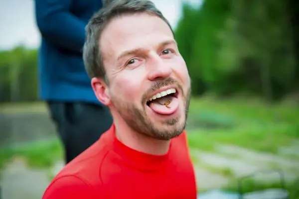 Lächelnder Mann trägt ein rotes Shirt und zeigt seine Zunge