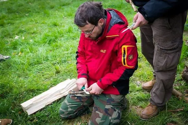 Messer bearbeitet Holzstück auf dem Boden