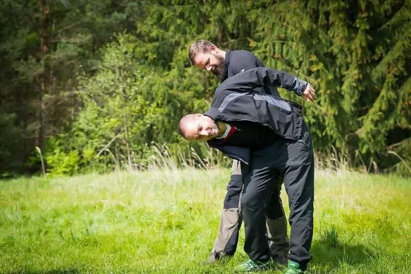 Person hilft anderer Person beim Bücken im Freien