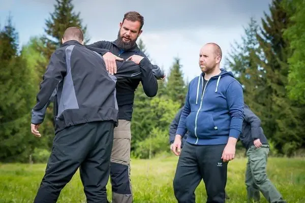 Training zur Selbstverteidigung mit mehreren Teilnehmern in einer Wiese