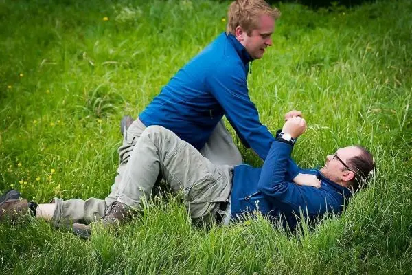 Zwei Personen liegen im Gras und üben eine Technik