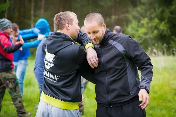 Zwei Personen üben eine Nahkampftechnik im Freien