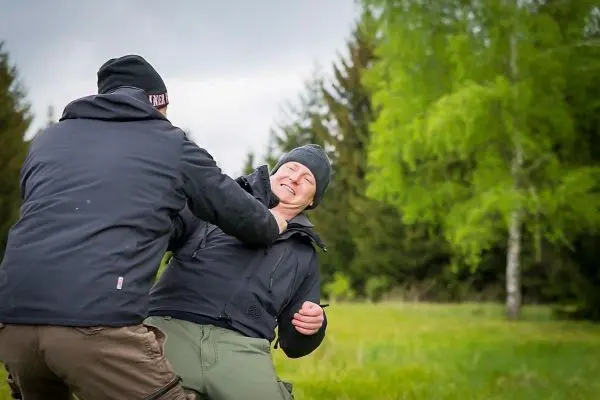 Zwei Personen üben eine Selbstverteidigungstechnik im Freien