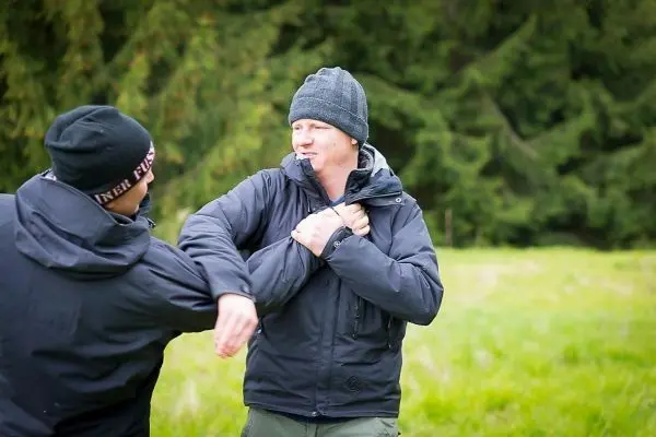 Zwei Personen üben eine Selbstverteidigungstechnik im Freien