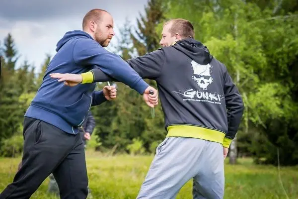 Zwei Personen üben eine Selbstverteidigungstechnik im Freien