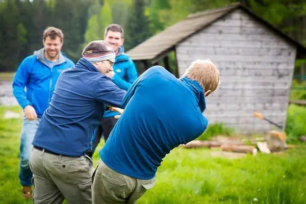 Zwei Personen ziehen an einem Seil, während andere zuschauen