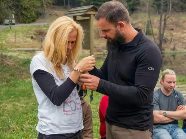 Ein Mann demonstriert das Anlegen von Handschellen an eine Frau