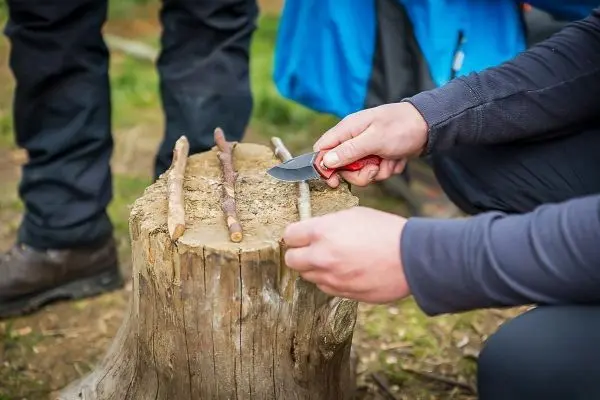 Ein Messer schneidet Holzstöcke auf einem Baumstumpf