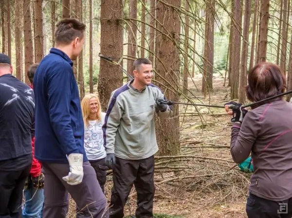 Gruppe arbeitet im Wald an einer selbstgebauten Seilquerung zwischen Bäumen