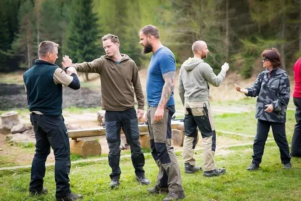 Gruppendiskussion über Techniken im Freien, mehrere Personen stehen zusammen