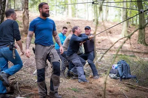 Gruppierung von Personen bei einer Seilquerung, eine Person zieht an einem Seil