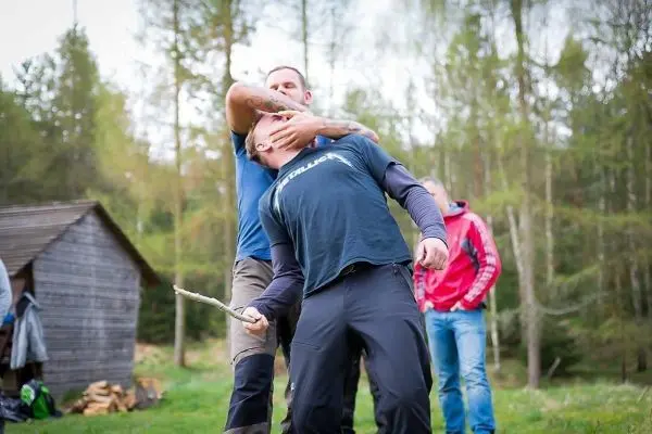 Kampftraining mit einem Stock in einer Waldumgebung