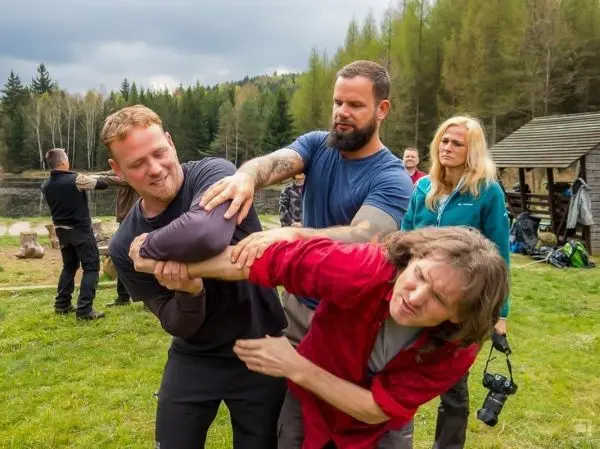 Kampftraining mit mehreren Personen im Freien, einer hält den Arm eines anderen fest