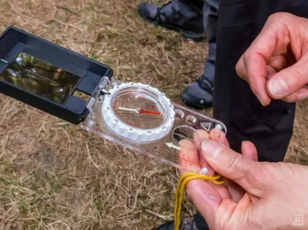 Kompass wird in der Hand gehalten, Zeiger zeigt auf Norden