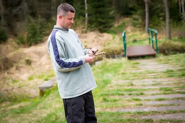 Mann hält ein Messer in der Hand und schaut darauf
