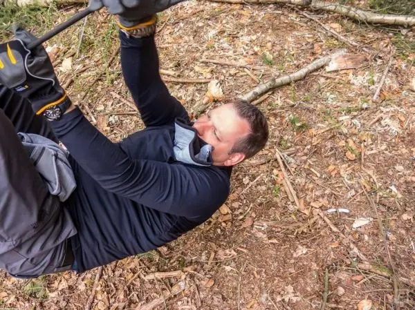 Mann überquert eine selbstgebaute Seilbrücke in der Natur