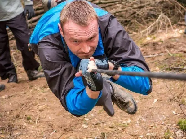 Mann überquert selbstgebaute Seilbrücke mit gespannten Seil
