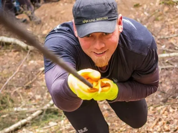 Mann zieht an einem Seil in einem Waldgebiet