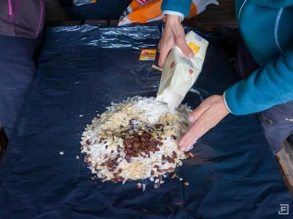 Mehl wird über eine Mischung aus Haferflocken und Rosinen gestreut