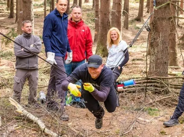 Selbstgebaute Seilquerung wird von einer Person überquert, während andere zuschauen