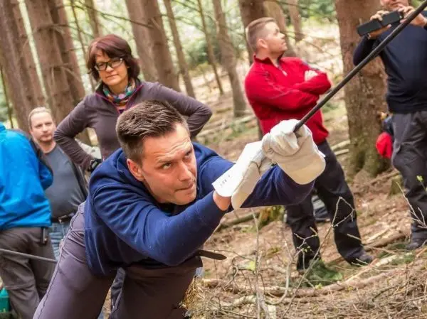 Teilnehmer zieht an einem Seil in einem Waldgebiet