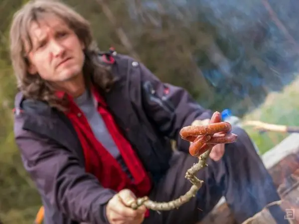 Wurststücke werden über einem kleinen Feuer geröstet