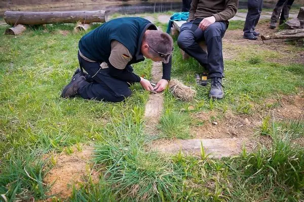 Zunder wird auf dem Boden vorbereitet, während eine Person sitzt und zuschaut