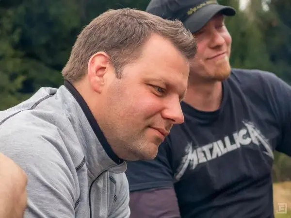 Zwei Männer sitzen nebeneinander und schauen nachdenklich in die Ferne
