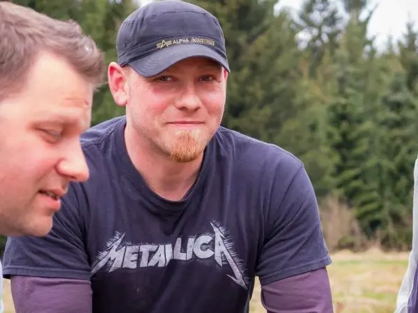 Zwei Männer stehen in einer natürlichen Umgebung und unterhalten sich