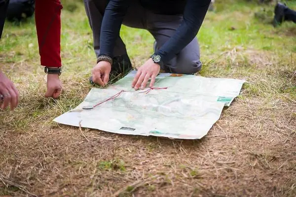 Zwei Personen analysieren eine Karte auf dem Boden