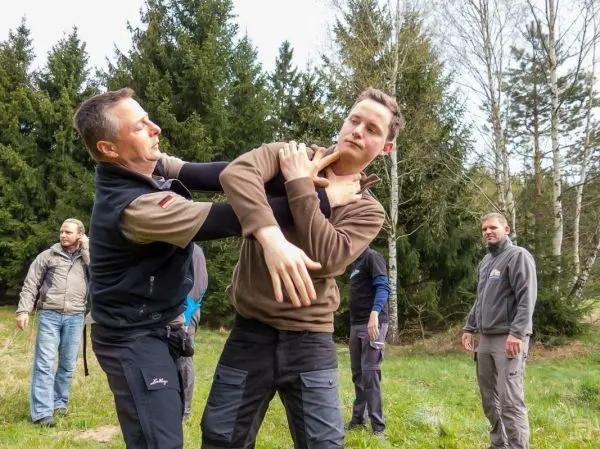 Zwei Personen demonstrieren eine Selbstverteidigungstechnik im Freien
