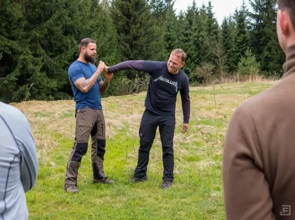 Zwei Personen demonstrieren eine Technik zur Handbefreiung im Freien